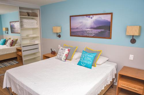 ein Schlafzimmer mit einem Bett mit Kissen darauf in der Unterkunft Flat Privativo Reserva do Mar in Angra dos Reis