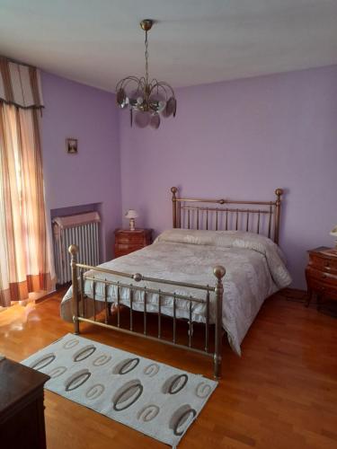 a bedroom with purple walls and a bed with a rug at Casa Gravere bis in Gravere