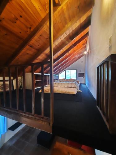 1 dormitorio en el ático con cama y techo de madera en Cabañas las palmeras en Don Torcuato