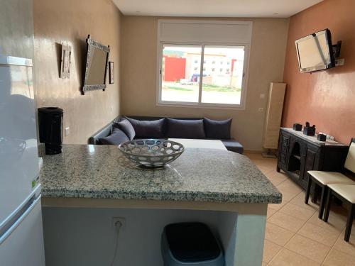 a kitchen with a counter and a living room at Europa mirlef t aventur Guest House in Mirleft