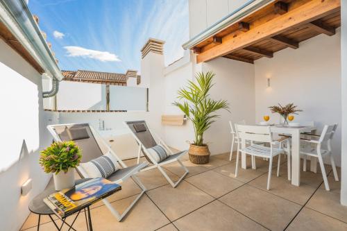 balcón con mesa y sillas y comedor en Debambú Suites, en Málaga