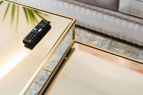 a remote control sitting on top of a glass table at Debambú Suites in Málaga