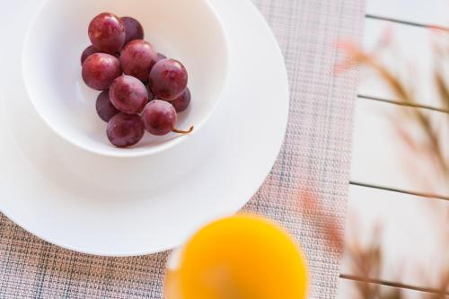 a plate of grapes and an orange on a table at Debambú Suites in Málaga