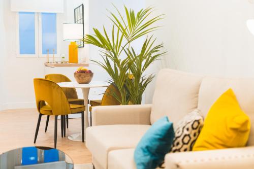 a living room with a couch and a table at Debambú Suites in Málaga