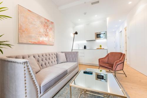 a living room with a couch and a table at Debambú Suites in Málaga