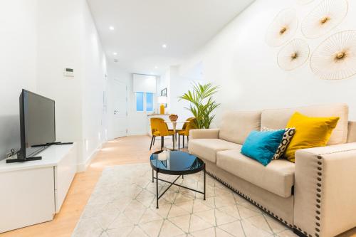a living room with a couch and a tv at Debambú Suites in Málaga