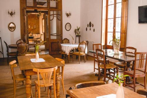 un comedor con mesas, sillas y ventanas en Posada Los Angelos en Ramallo