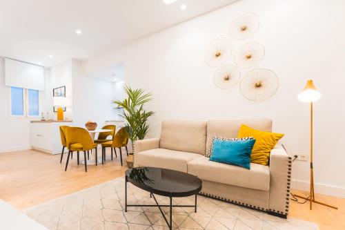 a living room with a couch and a table at Debambú Suites in Málaga