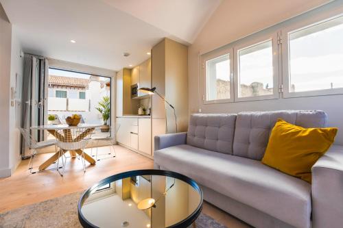 a living room with a couch and a table at Debambú Suites in Málaga