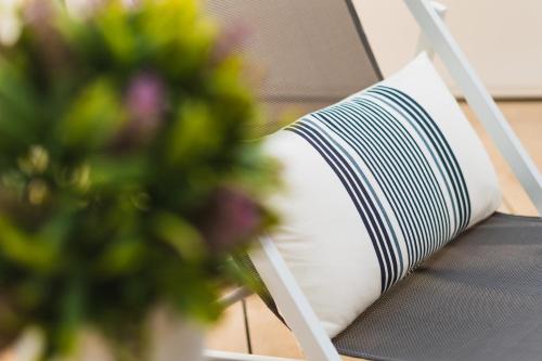 a book sitting on a chair with a vase of flowers at Debambú Suites in Málaga