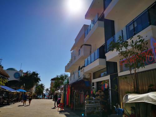 a street with buildings and people walking down a street at Paz-2 Norte estudios in Playa del Carmen