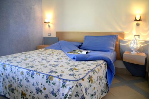 una camera da letto con un letto con lenzuola blu e un libro sopra di Masseria Asciano a Ostuni