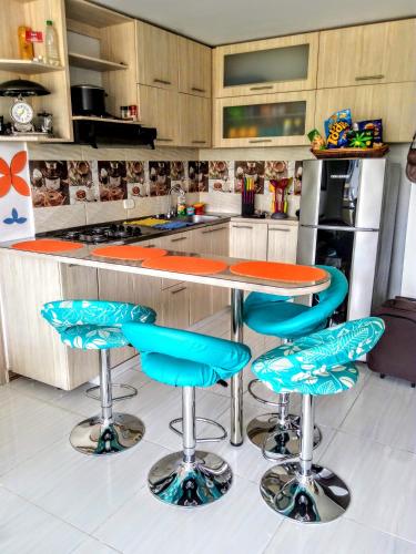 a kitchen with a counter with blue bar stools at PeñalisaKapoSalSar in Girardot