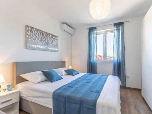 a bedroom with a large bed with blue pillows at Maslina in Vrsi