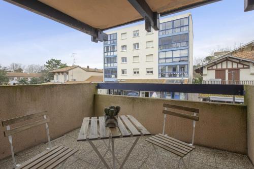 two chairs and a table on a balcony with a building at Appartement Sémaphore - Welkeys in Soorts-Hossegor