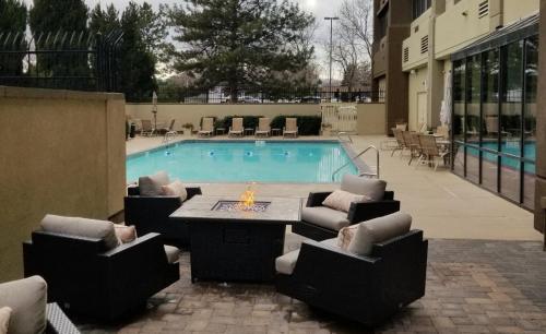 a swimming pool with chairs and a table and a table and a tablektop at Holiday Inn Denver Lakewood by IHG in Lakewood
