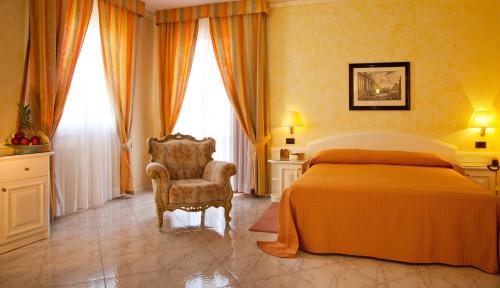 a bedroom with a bed and a chair at Hotel Villa Leri in Monte Colombo