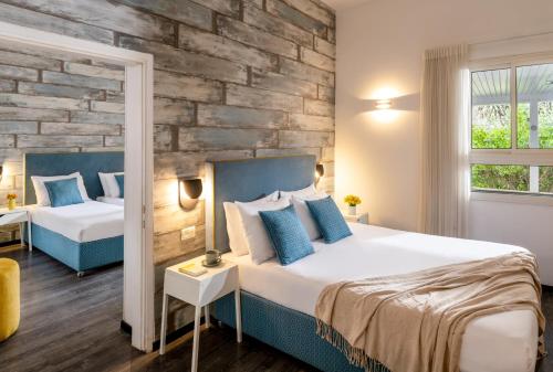 1 dormitorio con 1 cama grande y pared de ladrillo en Metulla Travel Hotel en Metulla