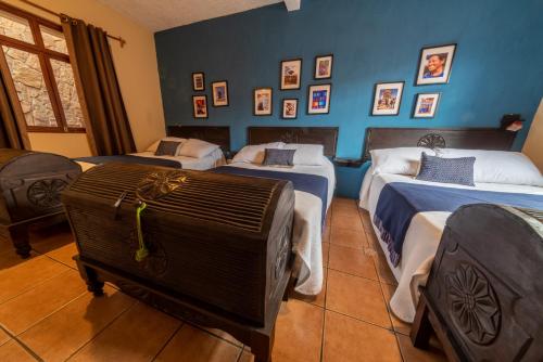 a room with three beds and a suitcase at 7 orejas in Quetzaltenango