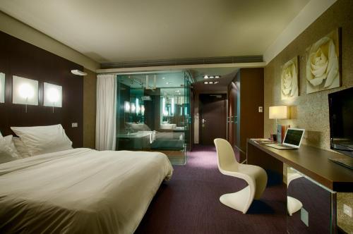 Le Rex Hôtel في تارْب: غرفة في الفندق مع سرير ومكتب مع لاب توب