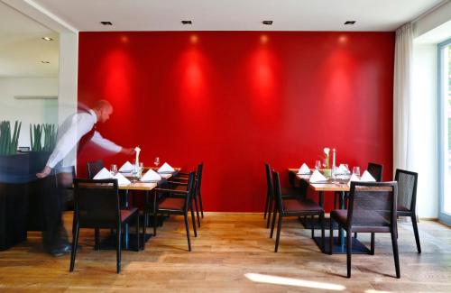 a man standing in front of a red wall in a restaurant at B&O Parkhotel in Bad Aibling
