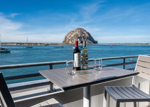 a table with two bottles of wine and two glasses at Inn At Rose's Landing in Morro Bay