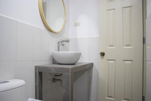 a white bathroom with a sink and a mirror at Hotel San Martin in Tarapoto