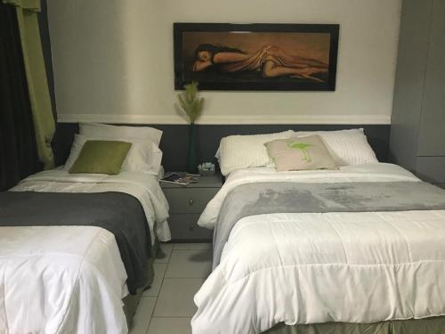 ein Schlafzimmer mit 2 Betten und einem Wandgemälde in der Unterkunft Aruba2023 in Oranjestad