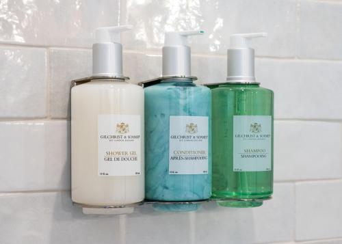 three bottles of detergent sitting on a bathroom counter at Inn At Rose's Landing in Morro Bay