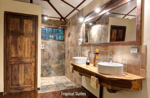 Baño con 2 lavabos y espejo en Tropical Suites & Villas, en Fortuna