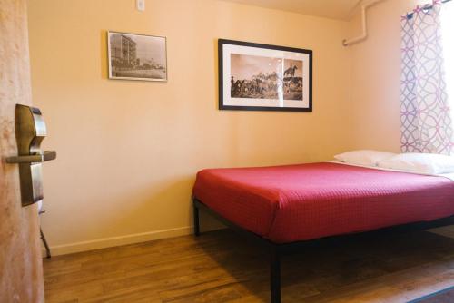 Habitación con cama con colcha roja en Old Brewery Hostel, en Tonopah