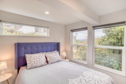 Un dormitorio con una cama azul y dos ventanas. en Holiday Beach House, en South Beach