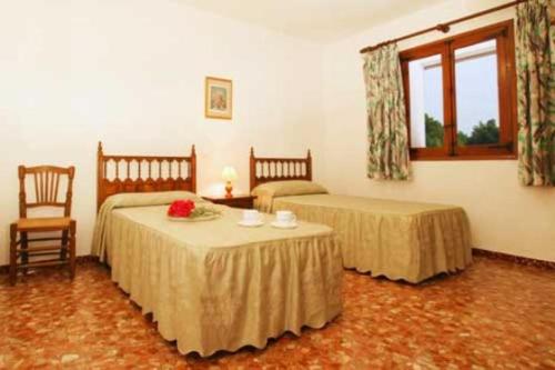 a bedroom with two beds and a table and a window at Holiday Home Bonestar in Jávea