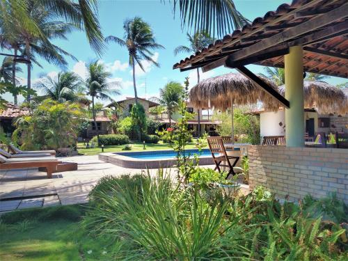 泰巴的住宿－Arco Mundial Taíba，一个带游泳池和棕榈树的度假村