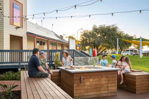 a group of people sitting around an outdoor bar at Discovery Parks - West Beach Parks in Adelaide