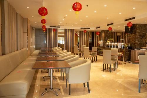 a row of tables and chairs in a restaurant at Orchardz Hotel Industri Jakarta Kemayoran in Jakarta
