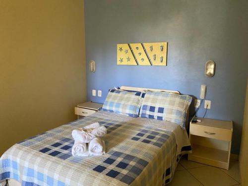 a bedroom with a bed with two towels on it at Pousada Maré Mar in Garopaba