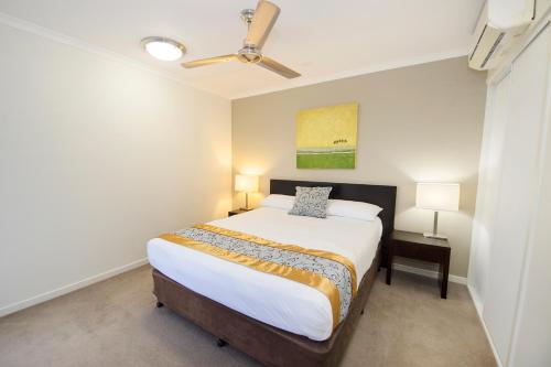 a bedroom with a bed and a ceiling fan at Gladstone City Central Apartment Hotel Official in Gladstone