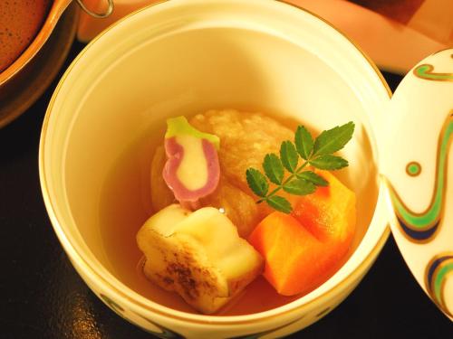 a bowl of food with fruit and sauce in it at Sapporo's Secret Onsen Sanctuary Marukoma Onsen Ryokan in Chitose