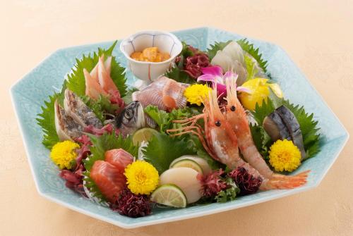 a blue plate of food with seafood and vegetables at Sapporo's Secret Onsen Sanctuary Marukoma Onsen Ryokan in Chitose