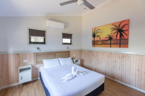 Un dormitorio con una cama con una toalla blanca. en Main Beach Tourist Park en Gold Coast