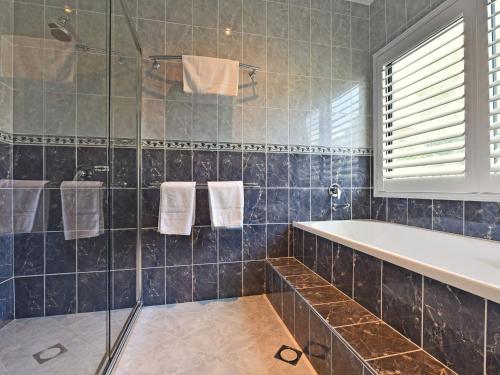 a bathroom with a tub and a shower at Sealand Lake House Stunning Absolute Waterfront in Fishing Point