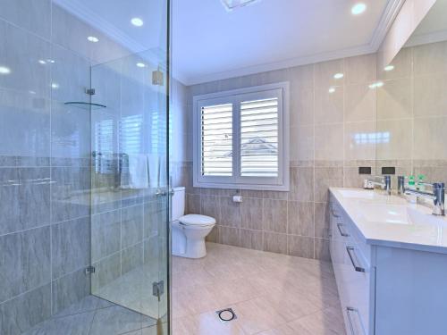 a bathroom with a shower and a toilet and a sink at Sealand Lake House Stunning Absolute Waterfront in Fishing Point