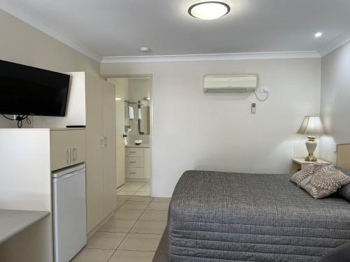 a small bedroom with a bed and a kitchen at Crows Nest Motel in Crows Nest