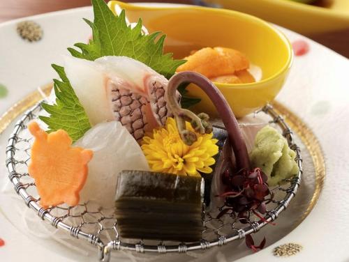 a plate of food with sushi on a table at Sapporo's Secret Onsen Sanctuary Marukoma Onsen Ryokan in Chitose