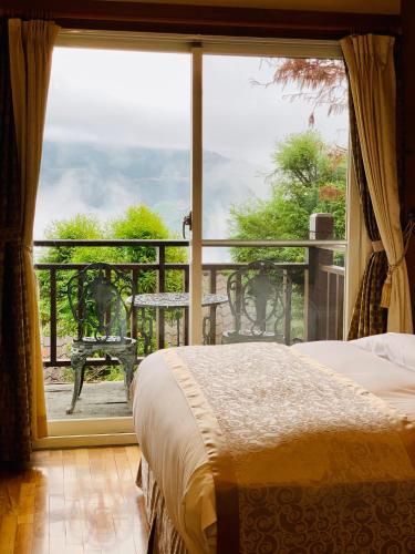 a bedroom with a bed and a large window at The Cotswolds Villa in Renai