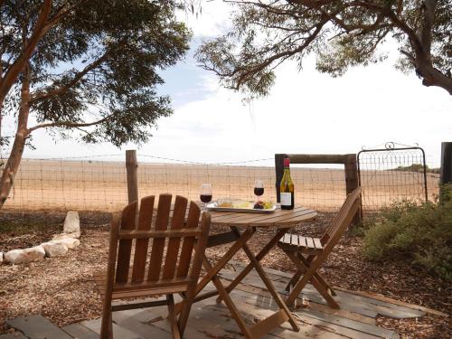 a picnic table with two chairs and a bottle of wine at The Old School House BnB in Kybunga