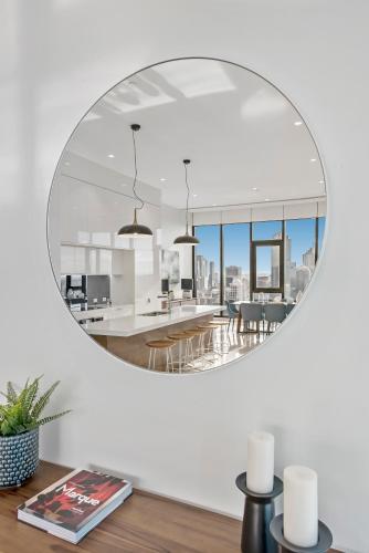a mirror in a living room with a dining room at Melbourne City Apartments Panoramic Skyview Penthouse in Melbourne