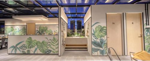 eine Lobby mit Türen und Pflanzen an den Wänden in der Unterkunft Cool Living in Jakarta