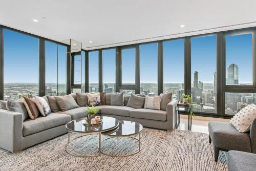 a living room with a couch and a table at Melbourne City Apartments Panoramic Skyview Penthouse in Melbourne